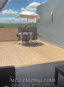a helicopter sitting on a deck with an umbrella at Casa de temporada em Jacaraípe in Serra