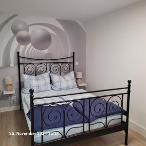 a bedroom with a black bed with blue and white pillows at Gemütliches Feriendomizil in Niederorschel