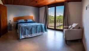 a bedroom with a bed and a chair and a window at Casa Canto do Bem-te-vi in Lençóis