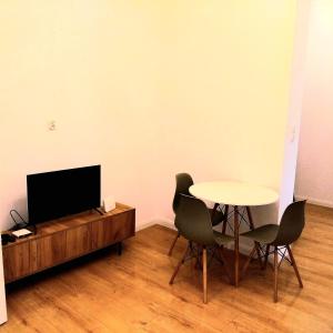 a living room with a table and a tv and chairs at Klonowicza One in Leszno