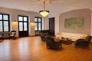 a living room with a couch and chairs and a piano at Romantik Hotel Schloss Reichenow in Reichenow