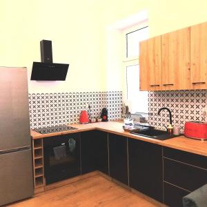 a kitchen with black cabinets and a black refrigerator at Klonowicza One in Leszno