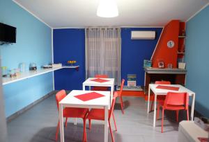 a dining room with two tables and red chairs at B&B Umballa in Praia a Mare