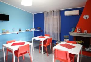 a dining room with two tables and red chairs at B&B Umballa in Praia a Mare