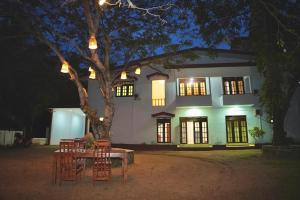 a table and chairs in front of a house at night at TENBY Guest House in Anuradhapura
