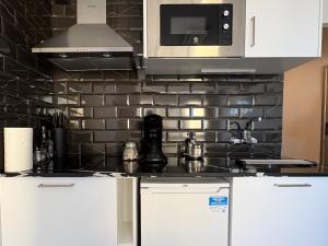 a kitchen with white cabinets and a microwave at Sweet Dreams Apartment, estilo y confort en 1ª línea, Renovado, Práctico y Anfitrión 5 Estrellas" in Empuriabrava +22 photos