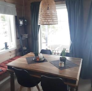 a dining room table with chairs and a large window at Hyttekos i Telemark in Åmli +8 photos