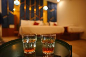 two glasses of whiskey sitting on a table in a room at SN Comforts in Bangalore