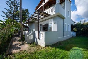 a white house with a window on the side of it at Esperado Gardens Maleme in Maleme +21 photos