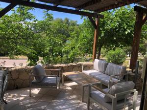a patio with a couch and chairs and a table at Casetta Jema in Lumio
