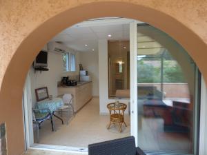 an archway in a room with a kitchen and a table at L'Ecureuil de l'Estérel in Saint-Raphaël