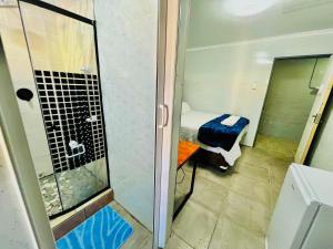 a small room with a shower and a bed at Honeyhills Excellence Resort E in Roodepoort +41 photos