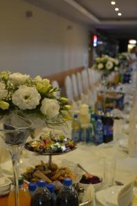 a long table with plates of food and flowers on it at Zajazd Tytan in Kochanowice