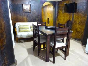 a dining room with a table and chairs and a couch at Apart Hotel La Bodega in San Rafael