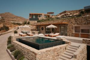 a villa with a swimming pool in a stone wall at GkF Luxury Villas in Naxos Chora