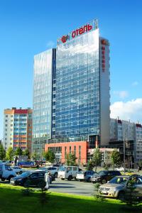 un gran edificio con un cartel en un estacionamiento en Spa Hotel Meliot, en Chelyabinsk