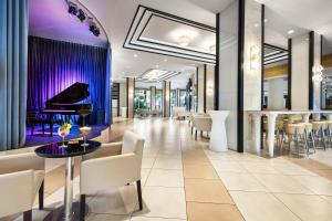 a lobby with a piano and a bar at Riu Plaza Miami Beach in Miami Beach