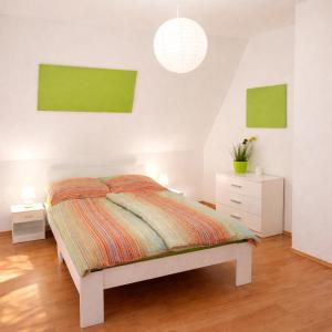 a white bedroom with a bed and two night stands at Fuchs & Hase im "Frau-Holle-Land" in Nentershausen