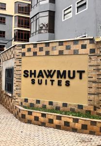 a sign for shawmut suites on a brick wall at Shawmut Executive Suites With Heated Pool, GYM, Secure Parking, Full Power Backup in Nakuru