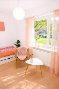 a bedroom with a bed and a chair and a table at Fuchs & Hase im "Frau-Holle-Land" in Nentershausen