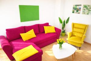 a purple couch and two yellow chairs in a living room at Fuchs & Hase im "Frau-Holle-Land" in Nentershausen