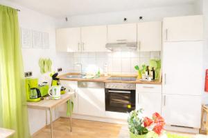 a kitchen with white cabinets and a green curtain at Fuchs & Hase im "Frau-Holle-Land" in Nentershausen +46 photos