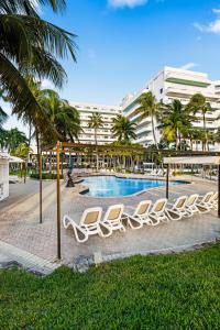 a row of lounge chairs next to a swimming pool at Riu Plaza Miami Beach in Miami Beach