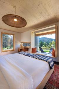 ein Schlafzimmer mit einem großen Bett und einem großen Fenster in der Unterkunft Eastwind in Windham