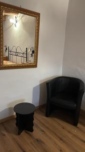 a living room with a black chair and a mirror at Casa di Mario in Graffignano