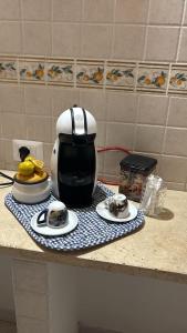 a tea kettle sitting on a counter with two plates of food at Casa di Mario in Graffignano