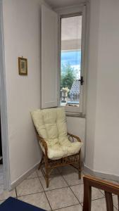 a chair sitting in a room with a window at Casa di Mario in Graffignano