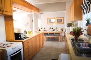 a kitchen with wooden cabinets and a table in it at LazyYzer in Yzerfontein +116 photos