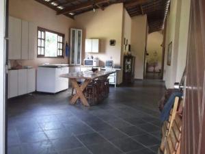 a large kitchen with a wooden table in a room at CHÁCARA STA EDWIGES/ARUJA in Arujá