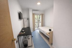 a room with a bed and a table and a door at Alicante Beach Hostel in Alicante +71 photos