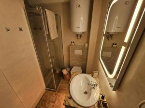 a small bathroom with a sink and a shower at White Blue Ohrid - Free Parking Balcony near Lake and Old Town Apartments in Ohrid +21 photos