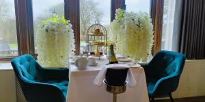 a table with a bottle of wine and flowers on it at Stanhill Court Hotel, a member of Radisson Individuals in Horley