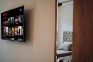 a television hanging on a wall in a room at White Blue Ohrid - Free Parking Balcony near Lake and Old Town Apartments in Ohrid