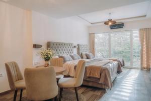 a bedroom with a bed and a table and chairs at White Blue Ohrid - Free Parking Balcony near Lake and Old Town Apartments in Ohrid