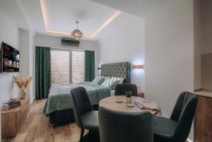 a bedroom with a bed and a table and chairs at White Blue Ohrid - Free Parking Balcony near Lake and Old Town Apartments in Ohrid
