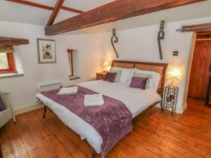 a bedroom with a large bed and wooden floors at The Bothy in Leyburn