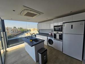 a kitchen with a white refrigerator and a sink at شقق باطلالات بانوراميه in Riyadh