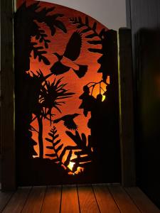 a door with a silhouette of butterflies and plants at Haven On Tau in Rangataua