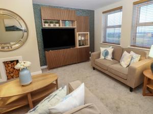 a living room with a couch and a tv at Eleven Tides in Seaham