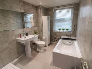 a bathroom with a tub and a toilet and a sink at Eleven Tides in Seaham +51 photos