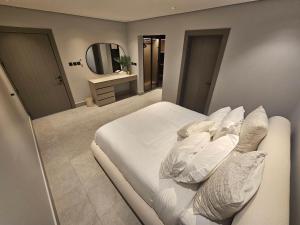 a bedroom with a white bed and a mirror at شقق باطلالات بانوراميه in Riyadh