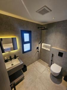 a bathroom with a toilet and a sink and a window at شقق باطلالات بانوراميه in Riyadh +11 photos