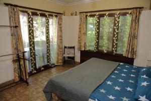a bedroom with a bed and two large windows at Minimax in Odesa
