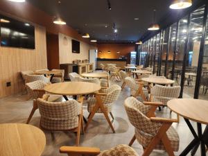 a restaurant with tables and chairs in a room at MIK Hotel Korça in Korçë