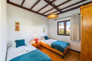 a bedroom with two beds and a window at Casa da Torreira in Torreira