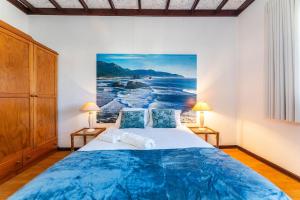 a bedroom with a bed and a painting on the wall at Casa da Torreira in Torreira +23 photos